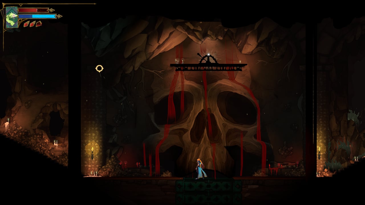 Video game screenshot of a large skull seen in the walls of an underground burial ground.