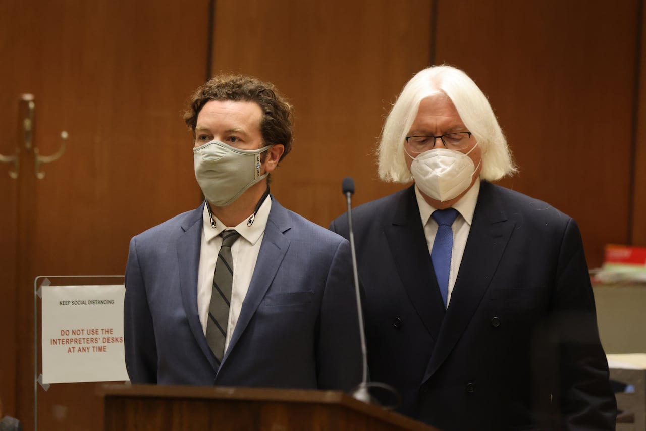 Two men wearing masks stand in a courtroom