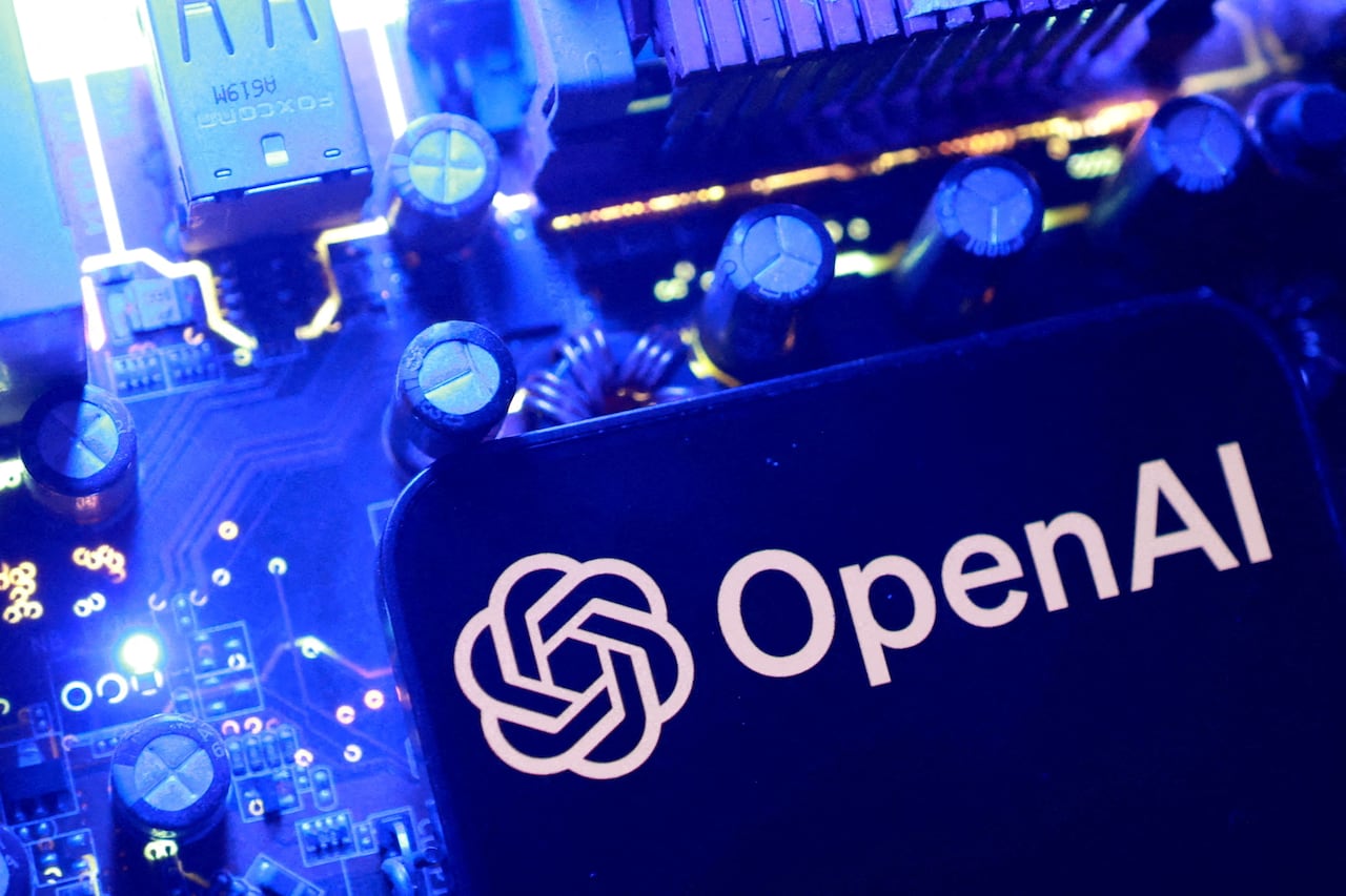 the open AI logo on a phone in front of a blue-lit switcherboard