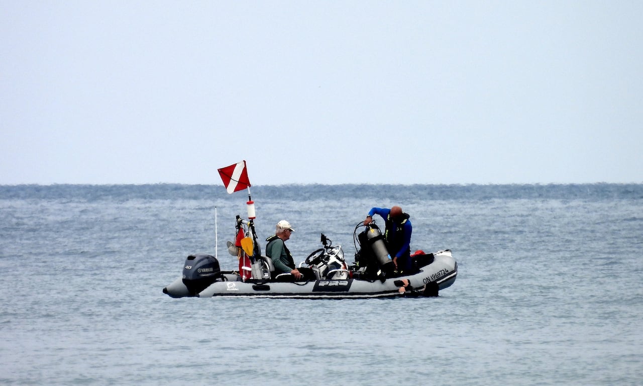 People in a boat and in the water