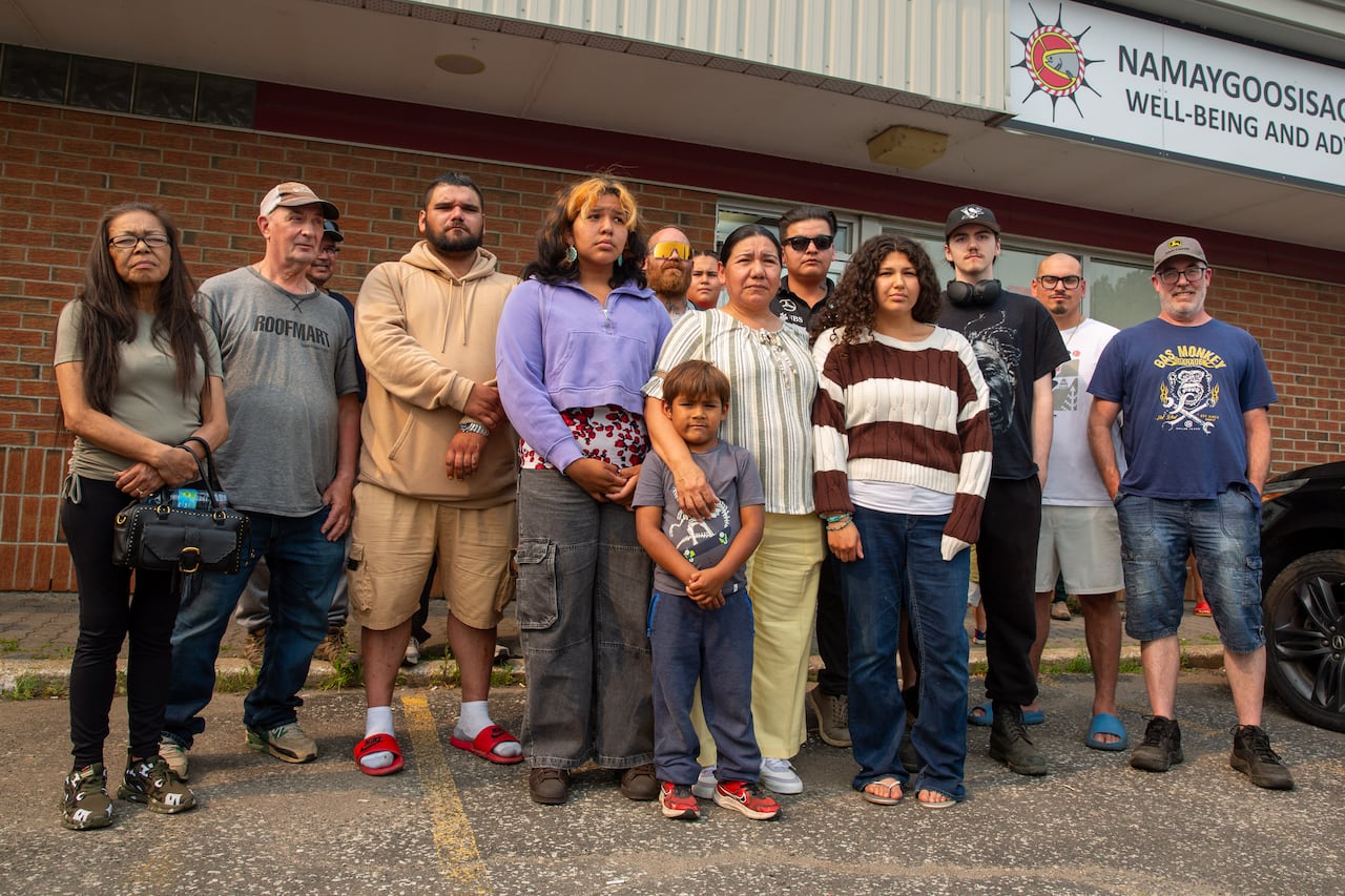 A group of people is seen standing in a parking lot.
