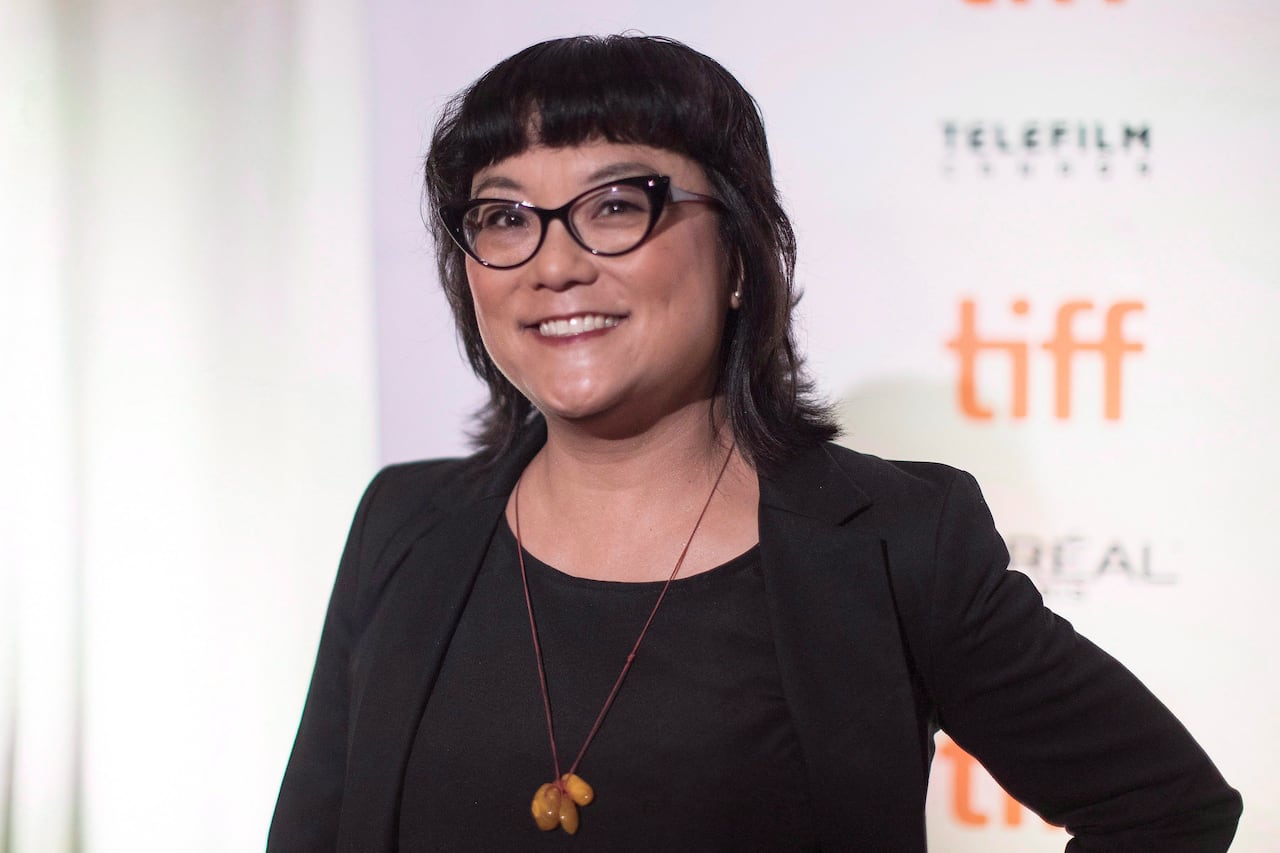 Woman with glasses smiles for the camera.