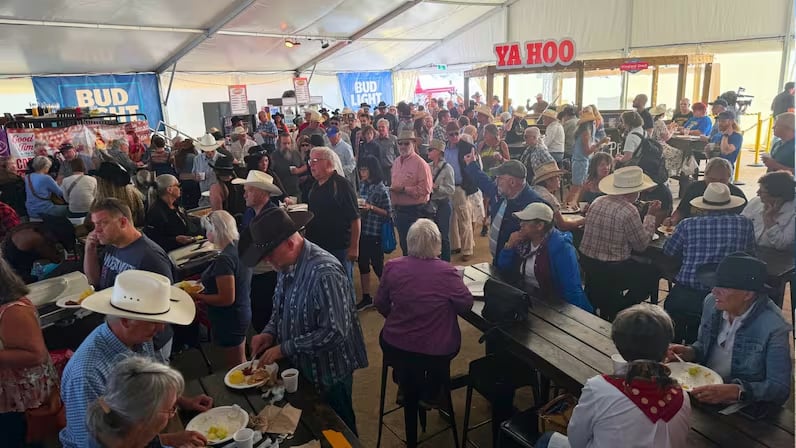 A room filled with people in cowboy hats at a pancake breakfast