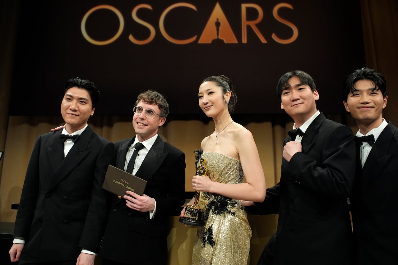 Five people at the Academy Awards stage.