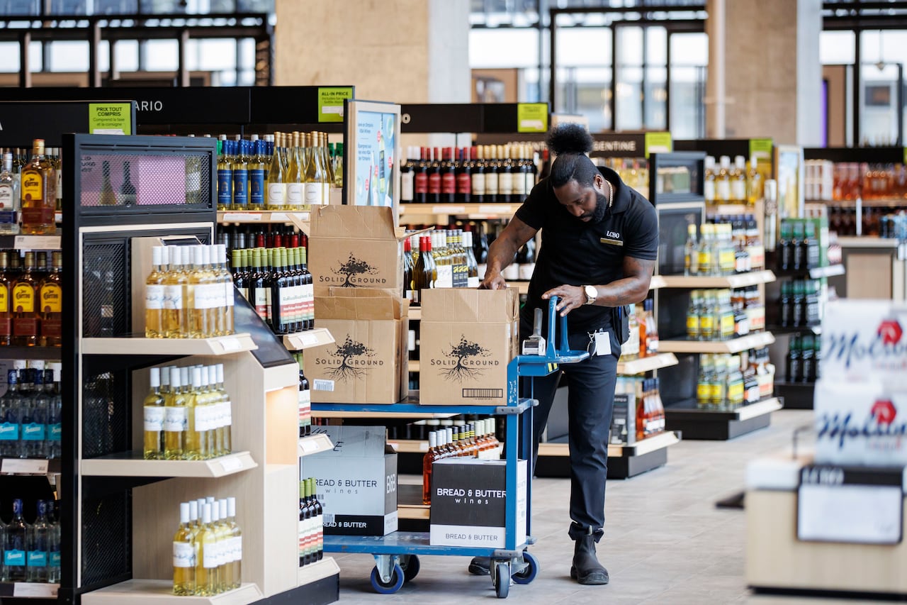 A liquor store employee loads wine into boxes.