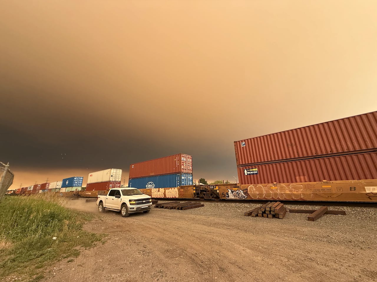 Wildfire smoke is seen above a train.