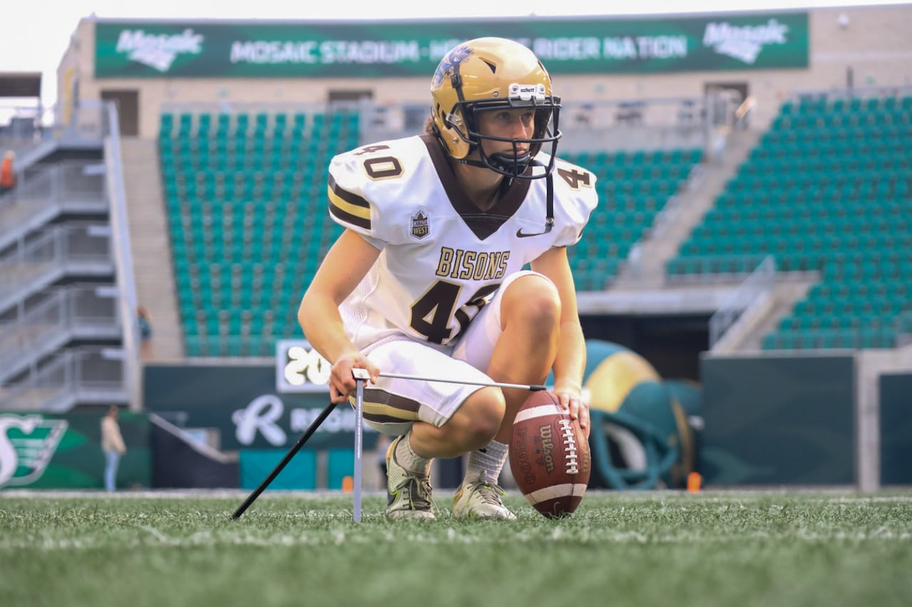 A female football player places a ball to get ready for a kick.