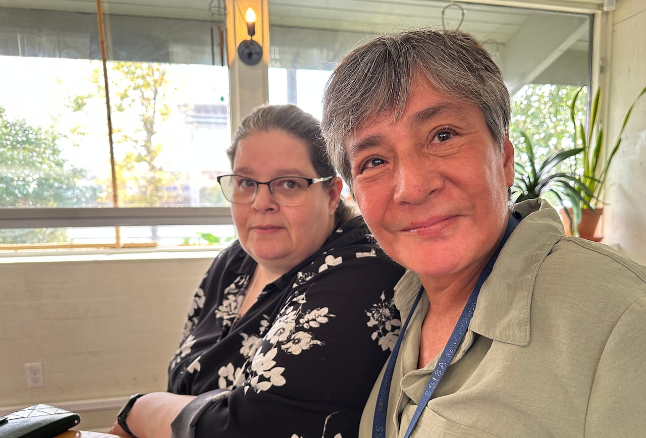 Two women sit at a table.