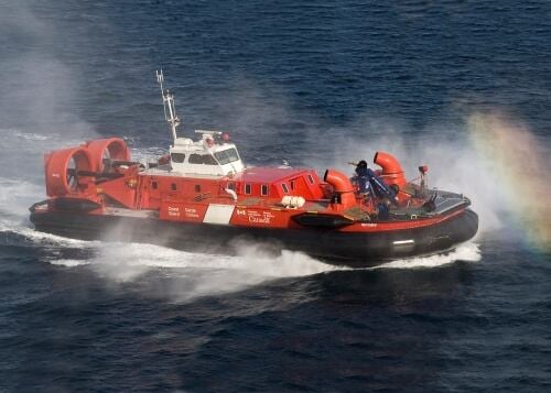 A coast guard hovercraft boat in the water.