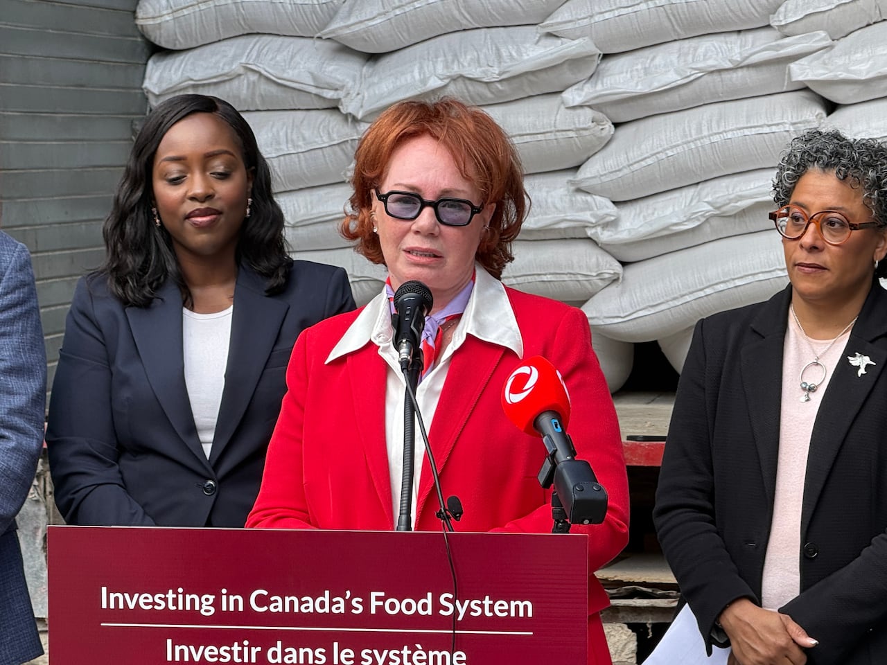 A red-haired woman speaking a podium