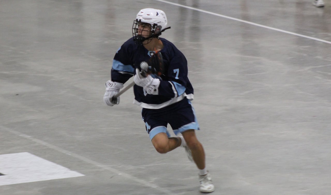 Lacrosse player carries ball in stick.