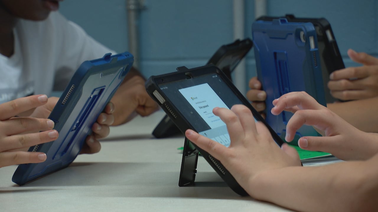 Children type on tablet computers, with the image focused on their hands close up.