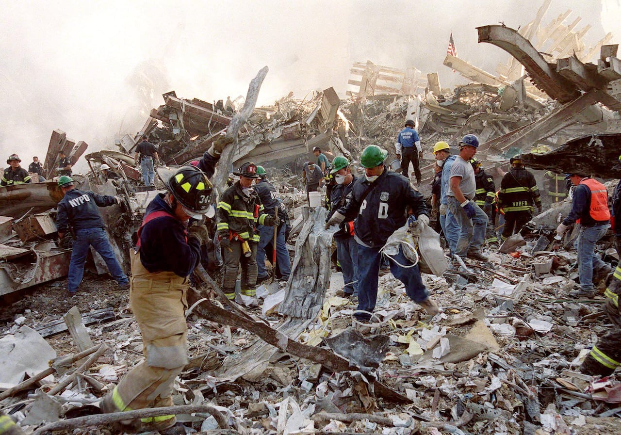 Firefighters and emergency personnel remove debris from the site of the World Trade Center towers' collapse in New York, Thursday, Sept. 13, 2001.