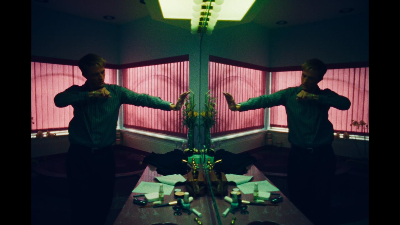 A man poses in front of a bathroom mirror