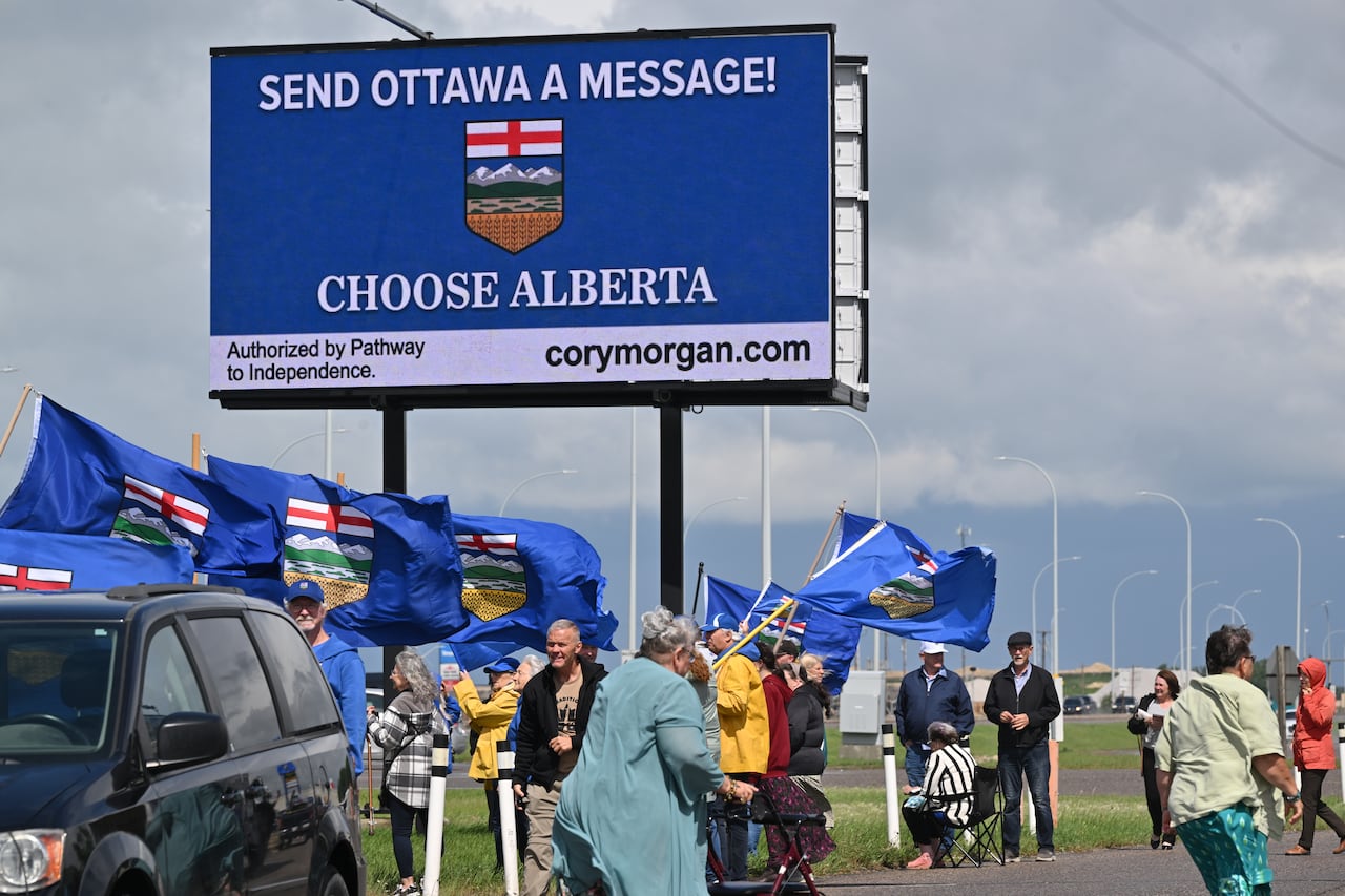 People gathering beneath a billboard that declares "Choose Alberta"