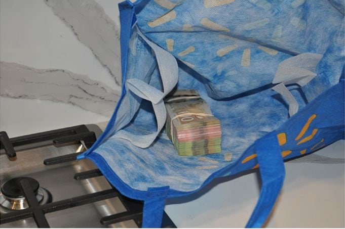 A photo shows a stack of cash inside a Walmart bag.