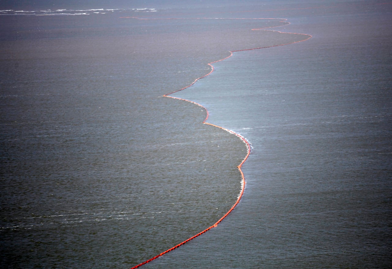 A wavy orange line bisects the Gulf of Mexico, splitting it between brown, oily water and cleaner blue water.