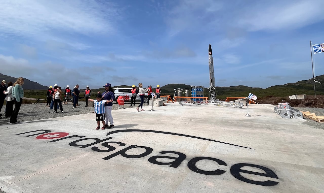 Tall rocket on concrete ground with words "nordspace."