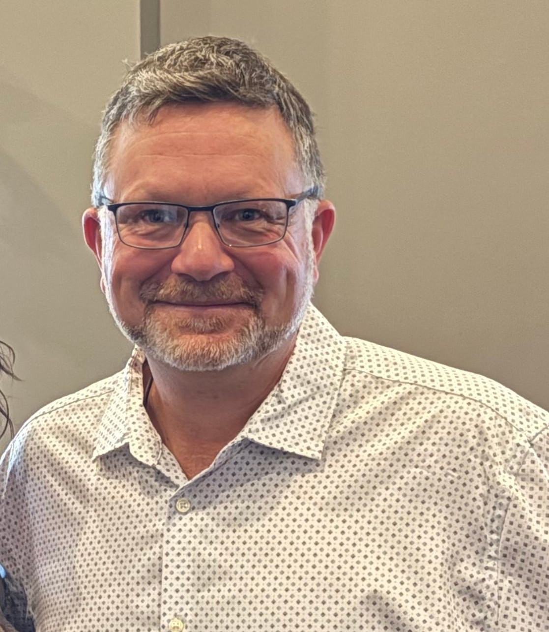 A man wearing glasses smiling