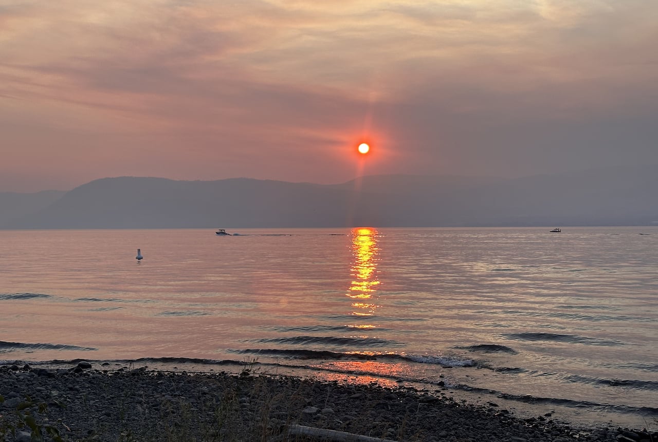 A smoky, orange sunset over a lake.