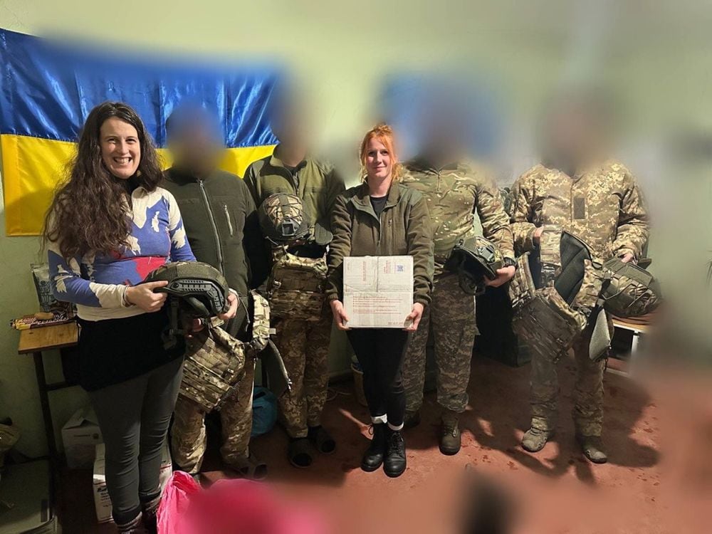Cardy stands with Ukrainian soldiers after delivering gear.