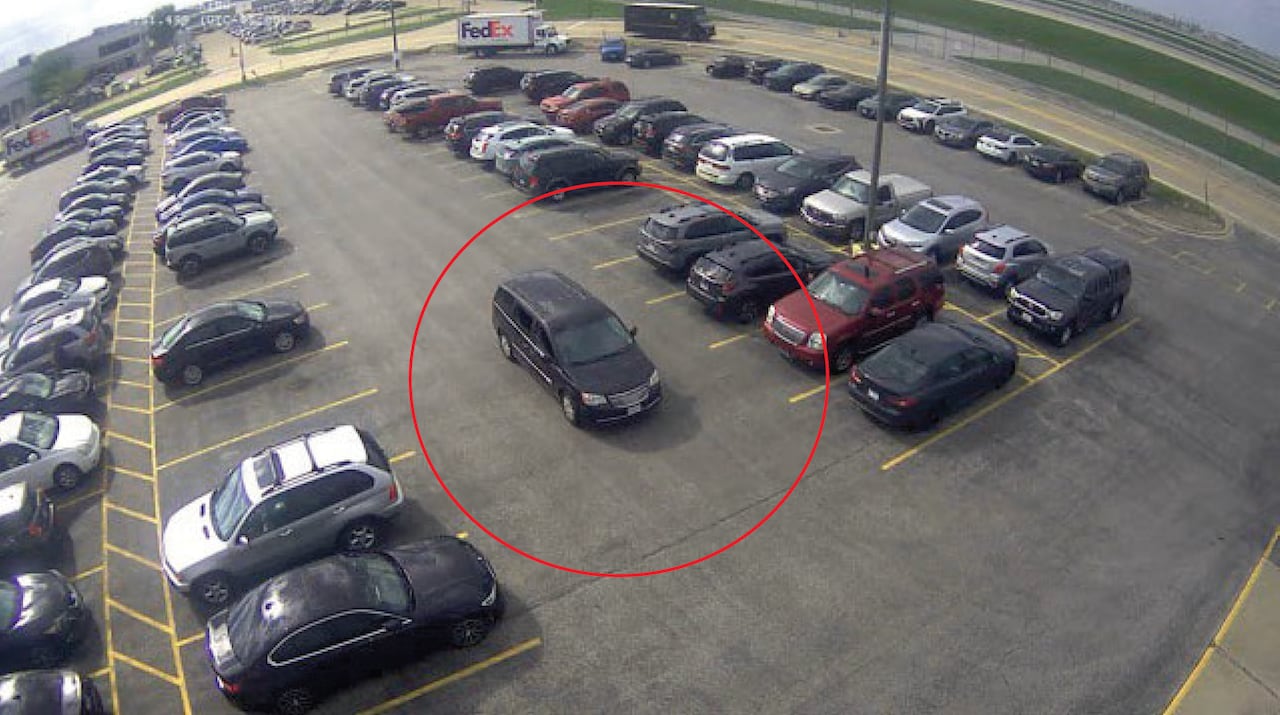 A red circle is drawn around a dark blue minivan in a parking lot.