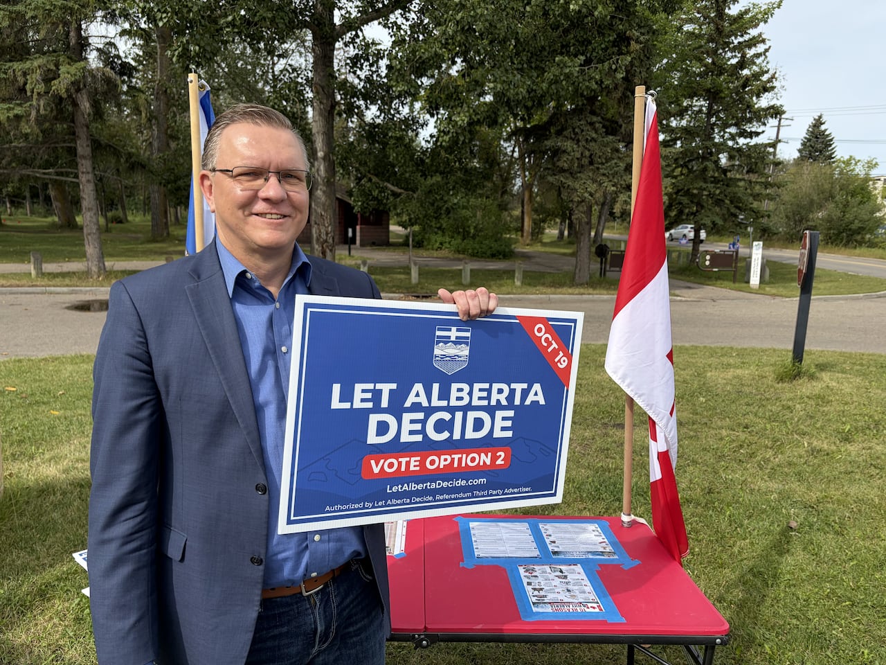 A man holds an Alberta sign