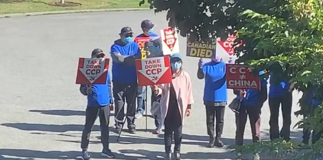 People are pictured on a road holding up signs.