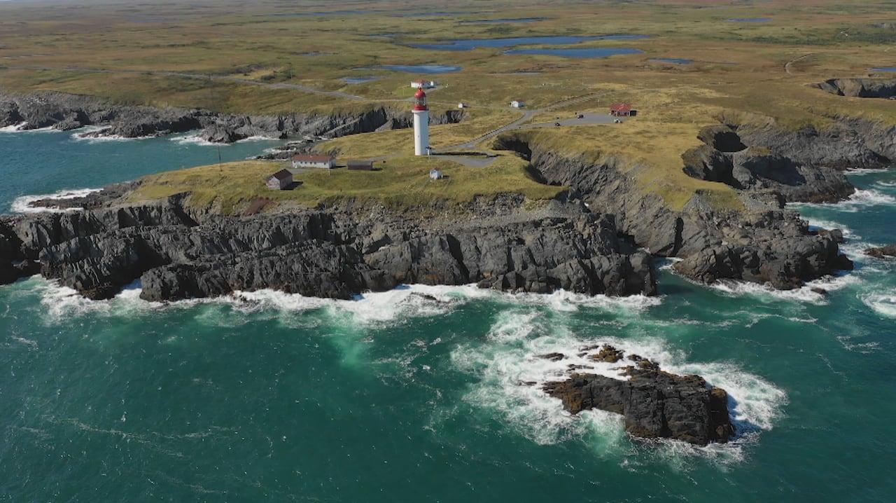 A drone captures an image of a beautiful coastline and lighthouse.