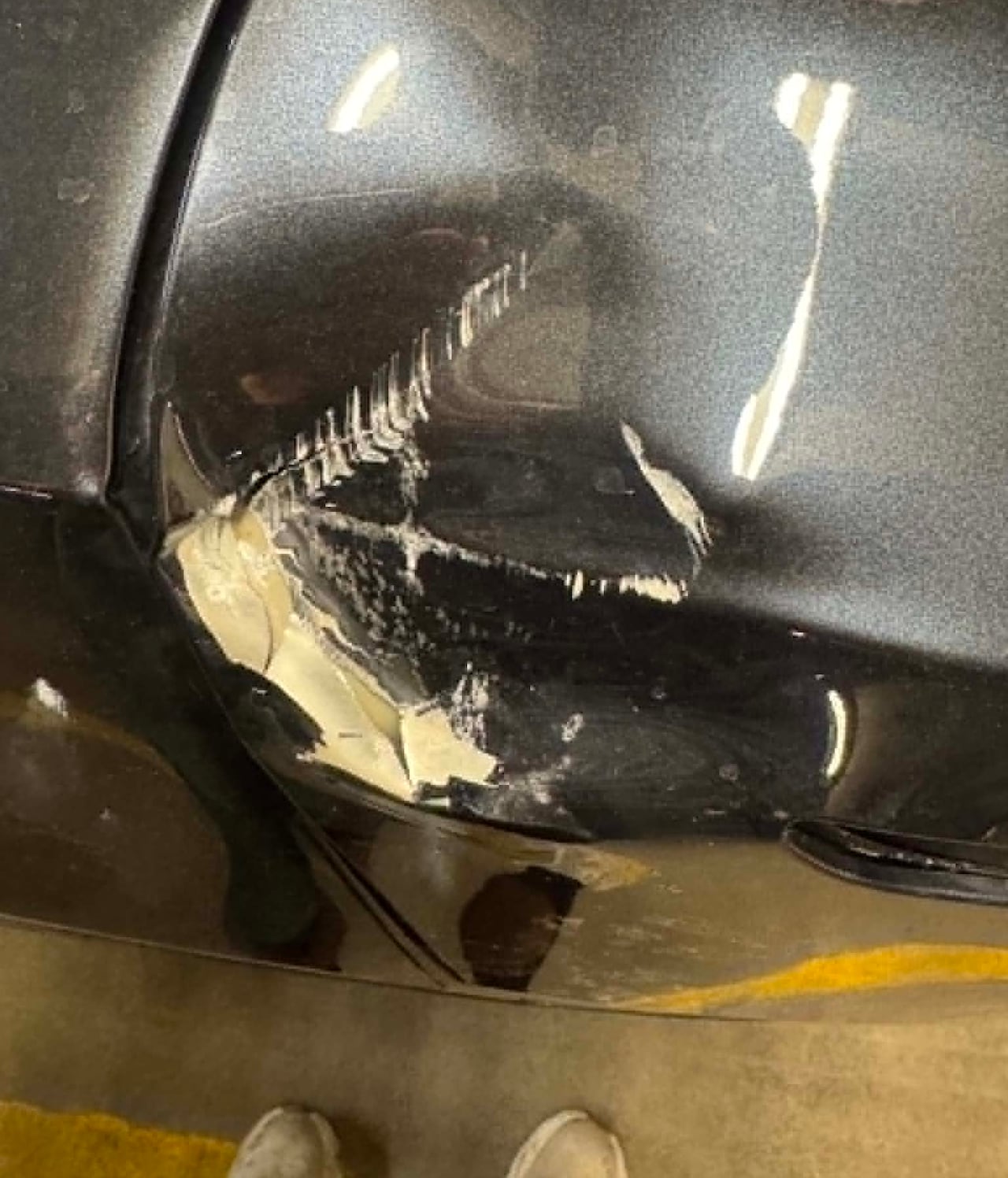 A damaged car door that is dented and has paint chipped