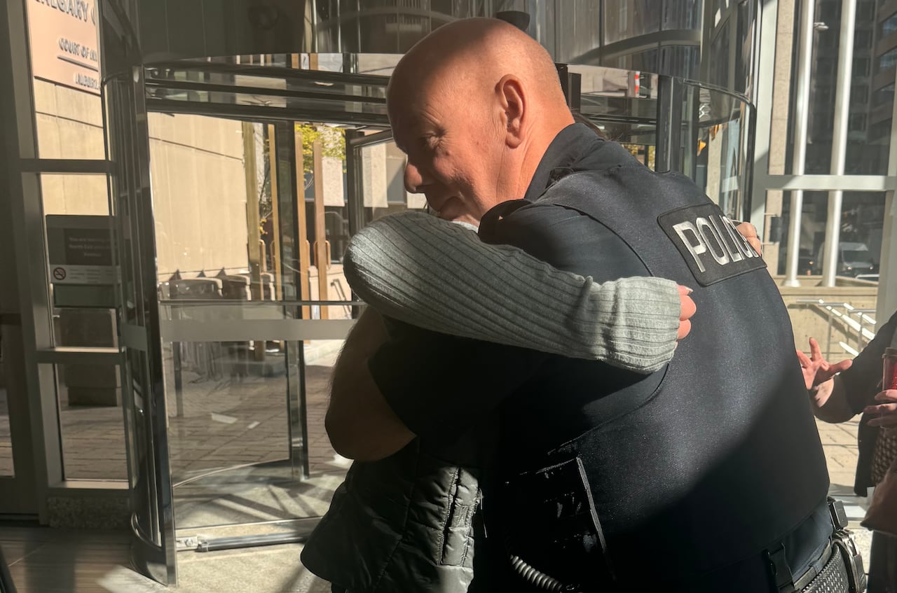 A woman hugs a police officer.