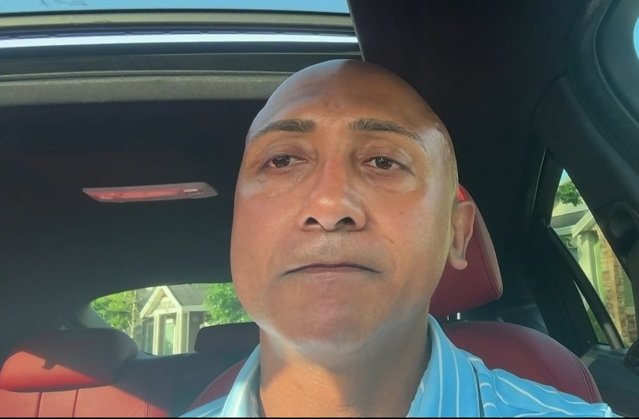 一名南亚裔男子在车内接受采访。