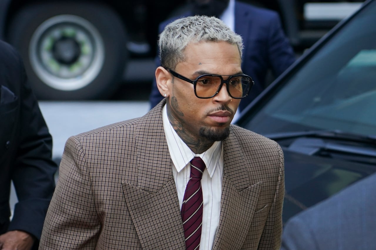 A man in a brown suit and glasses.