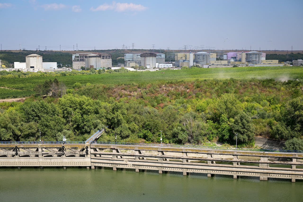 Five reactors next to a water channel, one is partially completed.