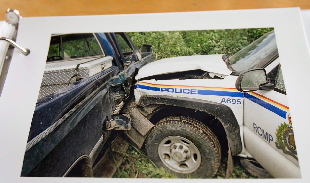 An evidence photo shows a police vehicle smashed into the side of a blue truck.