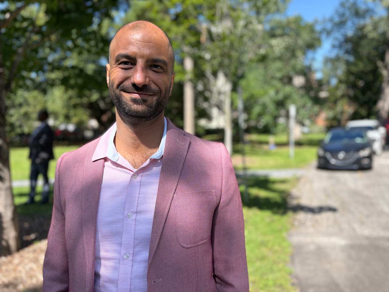 A smiling man in a pink suit