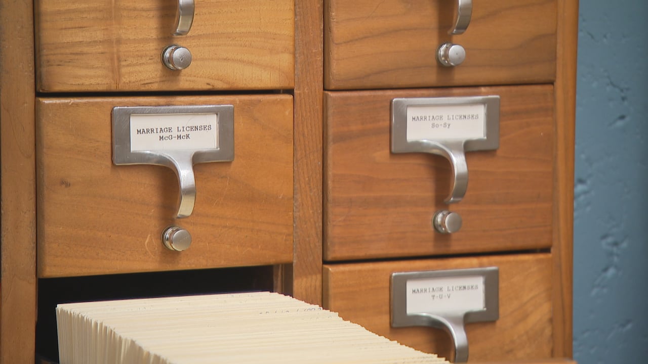 Brown archive boxes are shown with one open filled with files.
