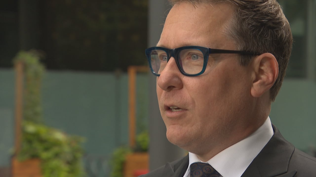 A man with glasses and a suit looking outward.
