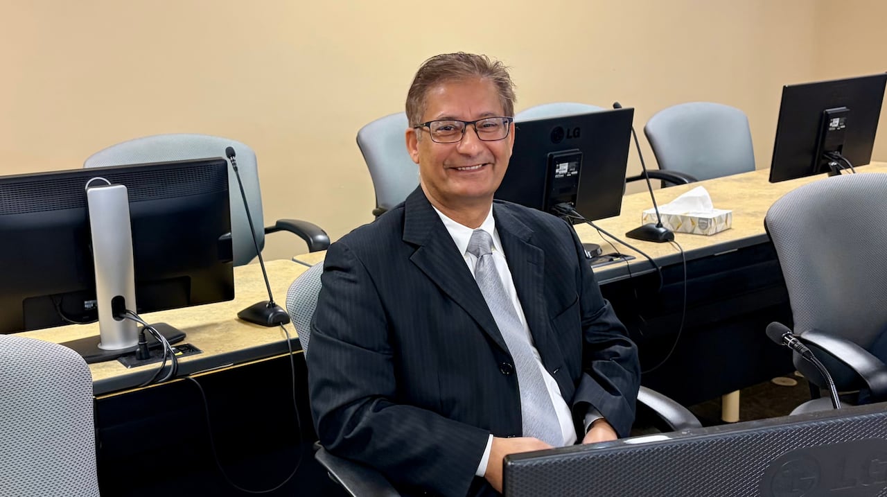 A man sitting behind a table.