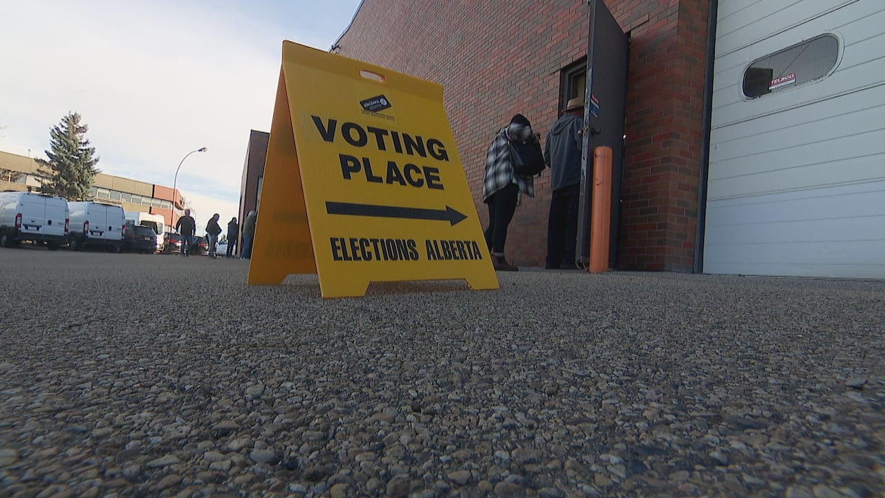 A yellow voting sign points to a door