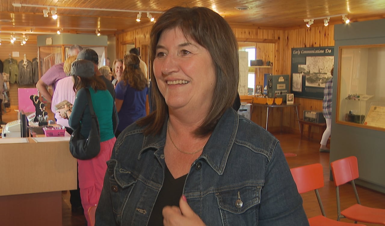 A woman in a Jean jacket stands in an interpretation center at Cape Race.