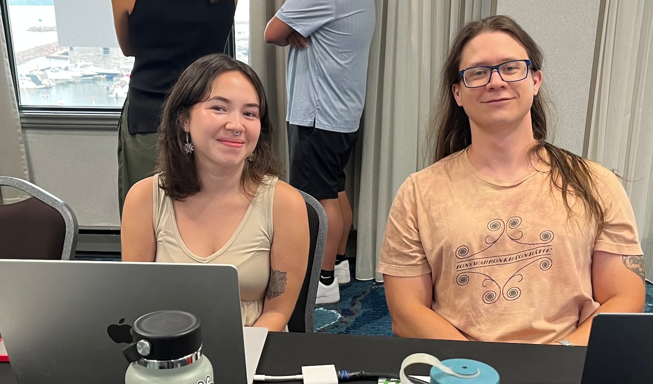 Woman and man sit at computer.