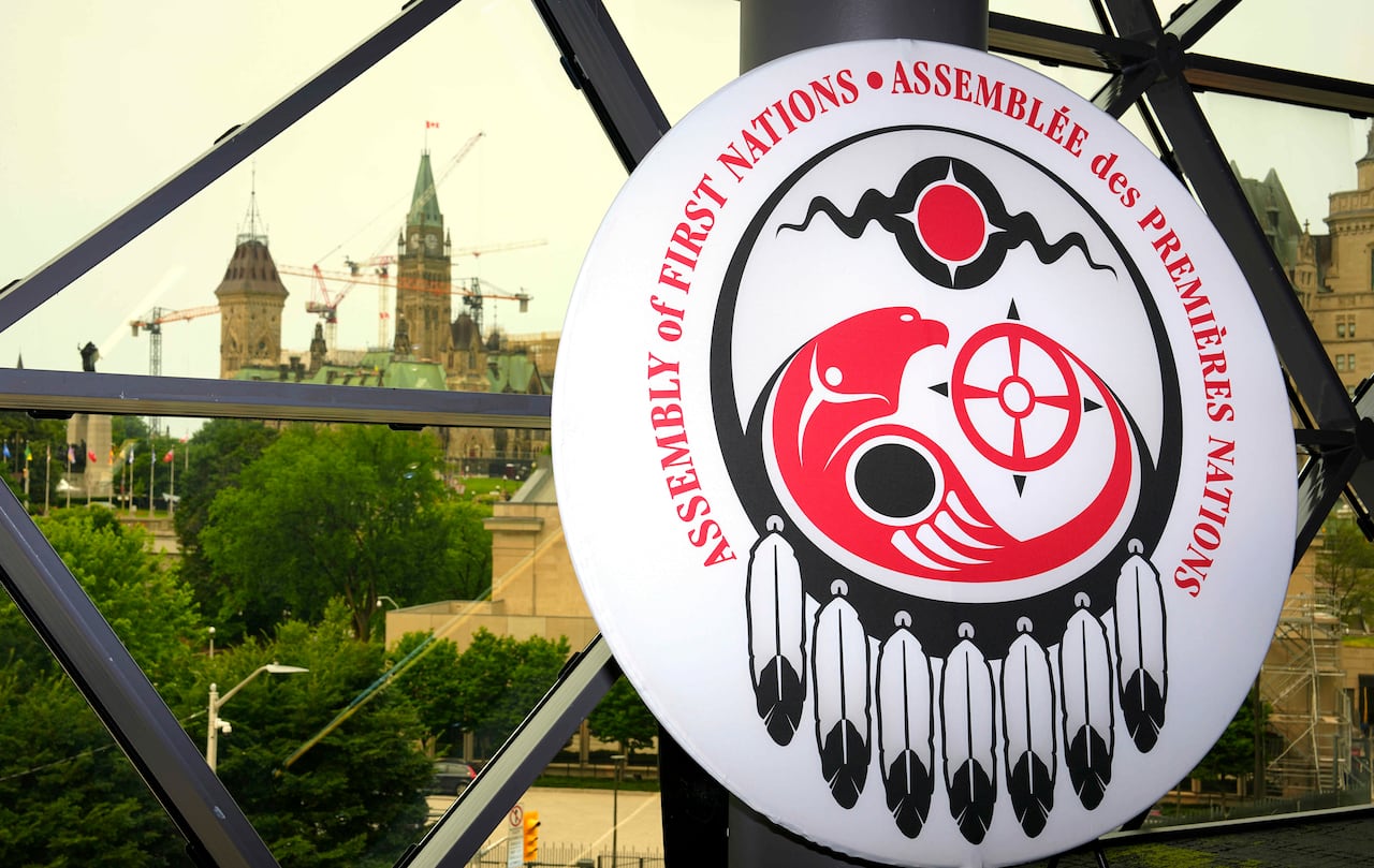 Parliament Hill is seen in the distance through a window with the AFN logo in the foreground..