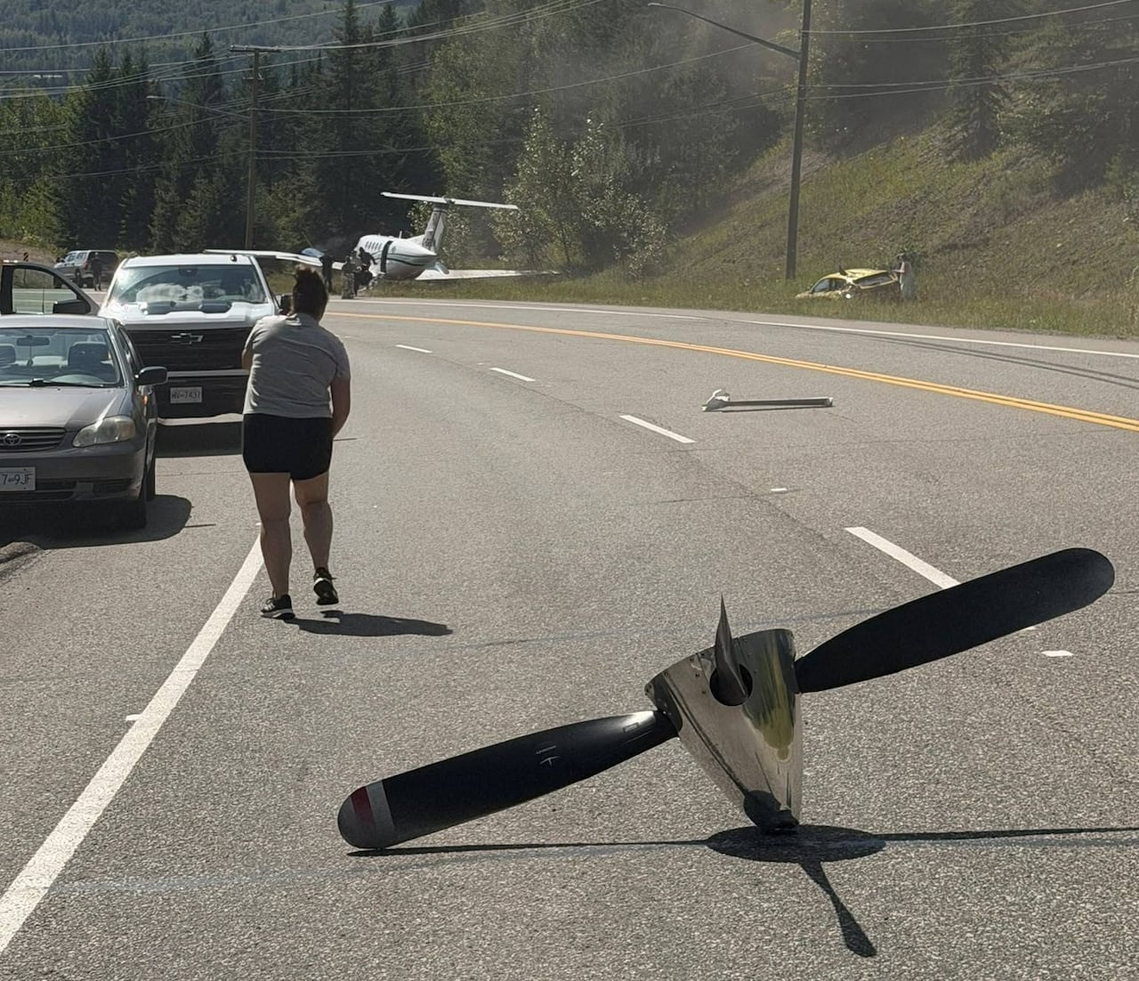 A propeller in the middle of a busy road at the scene of an emergency aircraft landing .