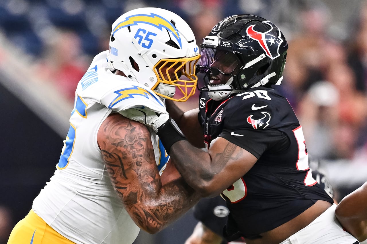 Two football players are shown colliding against each other, with their arms holding on to the other person.
