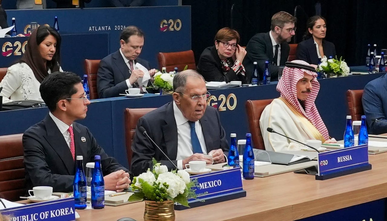 Men in suits sit at a diplomatic meeting.