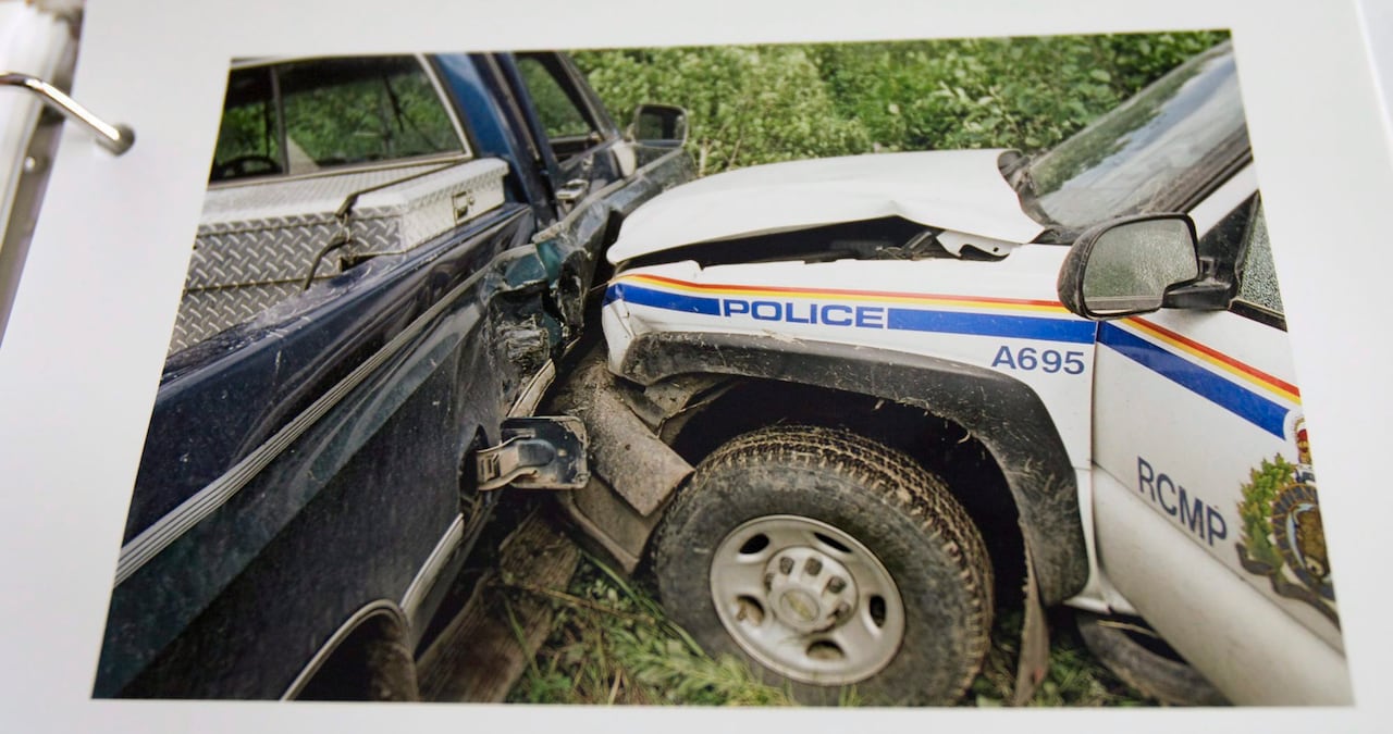 The front of an RCMP vehicle can be seen smashed into the side of a blue truck.