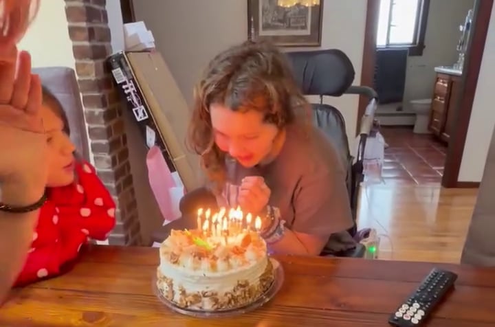 一名女孩正在吹生日蜡烛。
