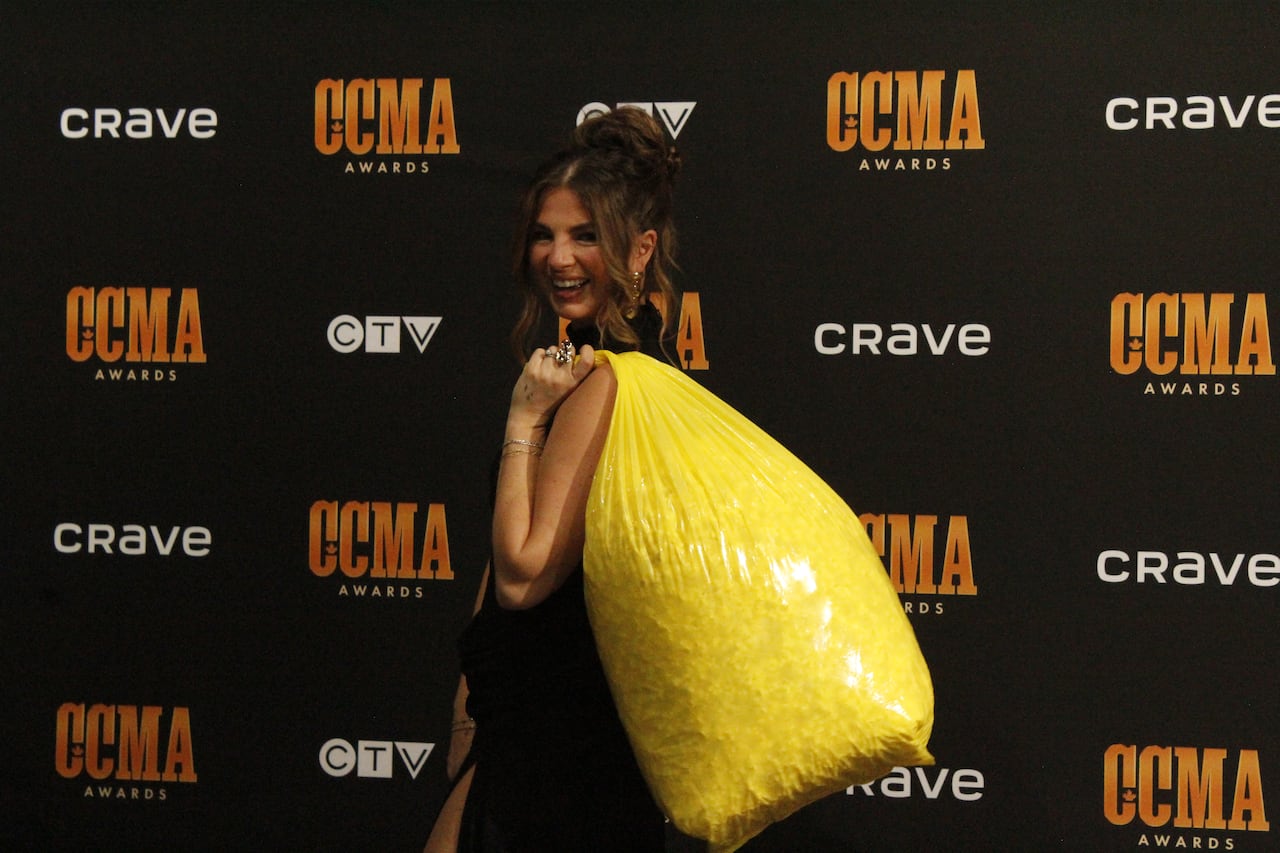 Jess Moskaluke with a garbage bag of popcorn over her shoulder.