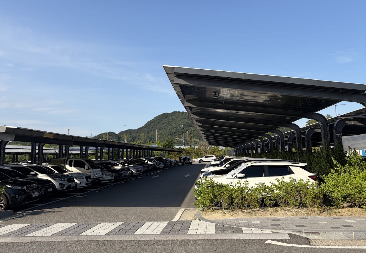 Cars parked under solar panel shelters